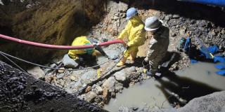 Trabajadores del Acueducto de Bogotá realizando labores de reparación en red de agua potable afectada por obras.