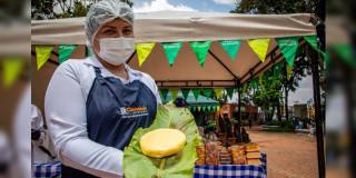 Foto de una de las mujeres que integran los Mercados Campesinos de Bogotá y productos lácteos.