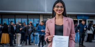 Foto de mujer con su hoja de vida en mano, asistiendo a unas de las Ferias de Empleo en Bogotá.