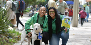 Fotografía de operarios del Distrito con un perro blanco 