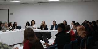 Foto de una mujer hablando en un auditorio sobre la vacunación en Bogotá