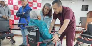 Foto de un operario atendiendo una mujer con discapacidad 