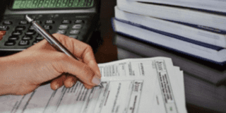 Fotografía de una mano firmando un documento 