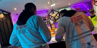 En la foto dos personas haciendo operativos de Inspección, Vigilancia y Control en un bar 