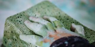 Fotografía de una mano moldeando una piedra