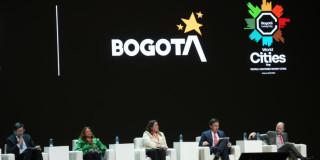 Foto que muestra cuatro personas sentadas en una tarima 