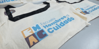 Imagen de unos talegos con el lema hombres al cuidado