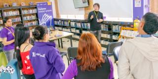 Foto que muestra personas hablando en una biblioteca 