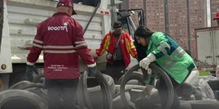 Foto que muestra trabajadores de la UAESP recolectando llantas en desuso
