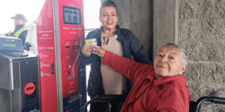 Imagen de dos señoras exhibiendo la tarjeta TuLlave 