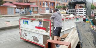 Foto que muestra una persona colocando residuos en un ecopunto 