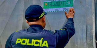 Foto de un policía sellando un establecimiento