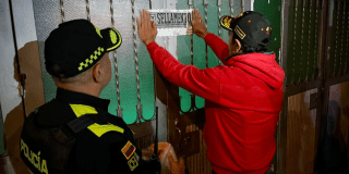 Imagen de un funcionario colocando el aviso de sellado a un establecimiento 