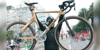 Imagen de un hombre que toma en sus manos una bicicleta.
