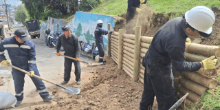 Foto de un equipo de trabajadores que construye un muro de contención