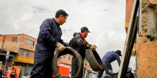 Foto de personas que recogen llantas usadas en una jornada de limpieza en Tunjuelito