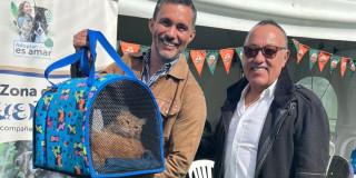 Foto de dos personas con un gato adoptado