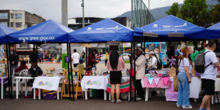 Foto de una fila de carpas azules con emprendimientos locales