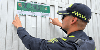 Foto de un policía sellando un establecimiento en Bogotá
