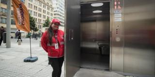 Señora posando con el baño público en Bogotá