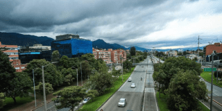 Imagen de panorámica de una vía principal de Bogotá donde se aprecia el cielo parcialmente nublado
