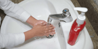 Foto que muestra una persona lavándose las manos