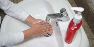 Foto que muestra una persona lavándose las manos