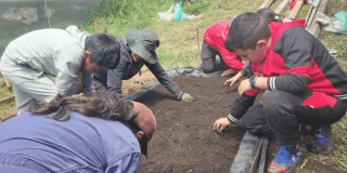 Foto de estudiantes cultivando la tierra