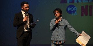 Imagen de un niño hablando ante el público en una tarima