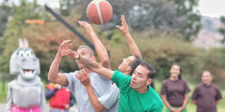 Imagen de tres personas disputando el balón de baloncesto