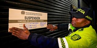 Policía pegando cartel de suspensión 