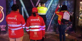 En la foto dos gestores de convivencia y la Policía sellando un establecimiento comercial