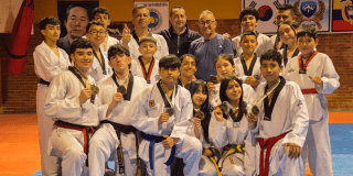 Niños y niñas tekwondistas posando con sus medallas