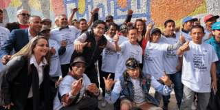 Imagen de los exhabitantes de calle al frente del mural