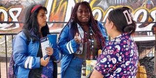 Foto de funcionarias del IPES con una vendedora informal socializando la guía para el uso responsable del espacio público en Bogotá.