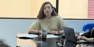 Foto de una mujer participando activamente en una reunión de trabajo.