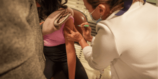 Foto que muestra una enfermera colocando una vacuna