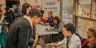 Hombres y mujeres en una de las ferias de empleo de 'Talento Capital' y la imagen de la Megaferia de Empleo.