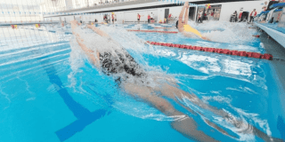 Imagen de una mujer nadando en una piscina olímpica