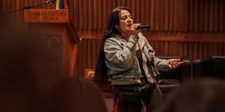 En a foto una señora hablando con un micrófono en un evento en Bogot´