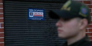 Imagen de un policía borroso y de fondo un local sellado