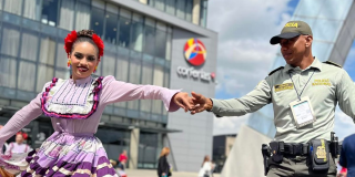Imagen de un Policía con una mujer vestida de un traje típico colombiano