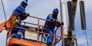 Foto que muestra trabajadores de Enel Colombia realizando sus labores en un poste de luz