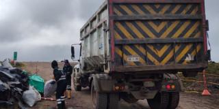 Foto que muestra trabajadores de la UAESP recogiendo basuras