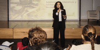 Imagen de funcionaria exponiendo en auditorio