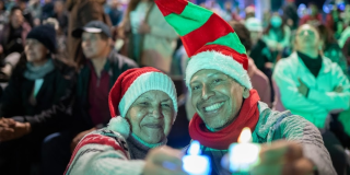 Imagen de personas con gorro navideño y velias
