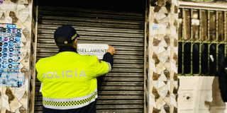 Imagen de un policía sellando un establecimiento