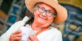 En la foto una mujer de la tercera edad feliz y tomando café 