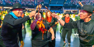 Imagen de personas mayores bailando y alzando una cuchara