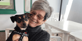 Imagen de una señora alzando a un perro